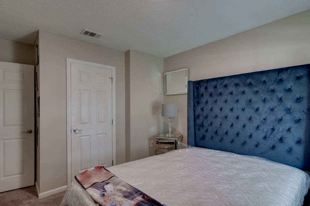 a bedroom with a large bed and a blue headboard