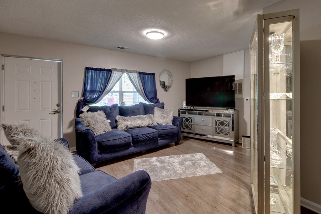 a living room with blue couches and a tv