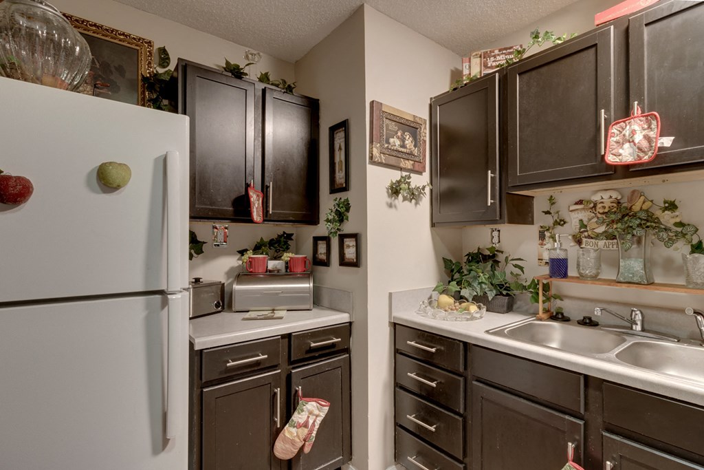 a kitchen with black cabinets and white appliances and a refrigerator