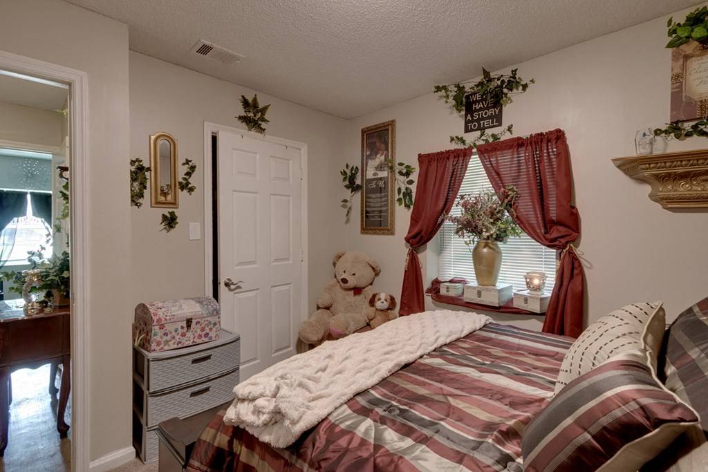 a bedroom with a bed and a teddy bear in it