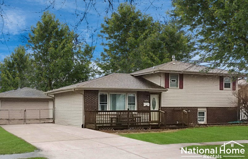 A house with a brown roof and a porch is for rent.