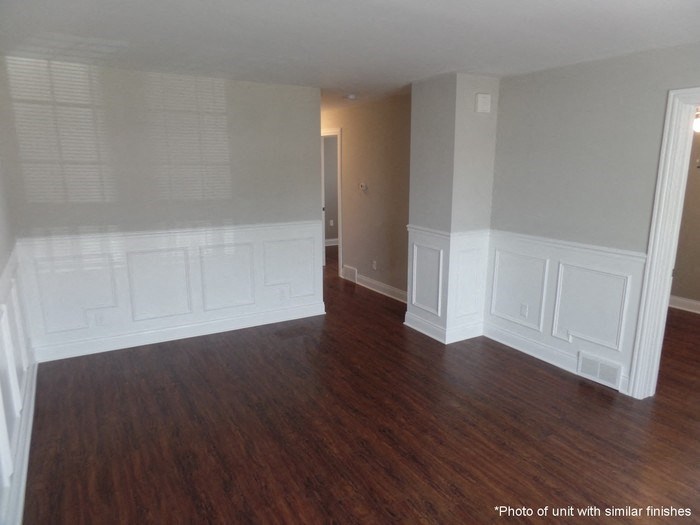 A room with wood flooring and white walls.