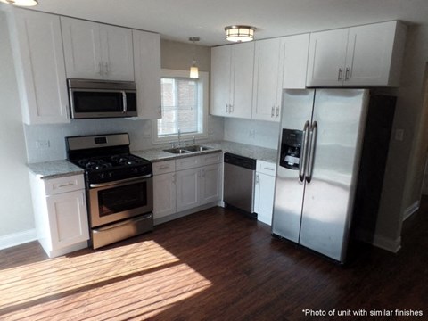 A kitchen with white cabinets and stainless steel appliances.