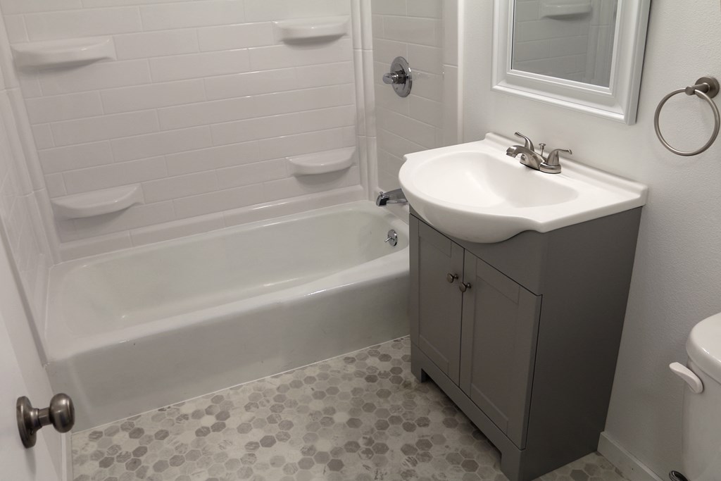 a small bathroom with a sink and a tub and a toilet