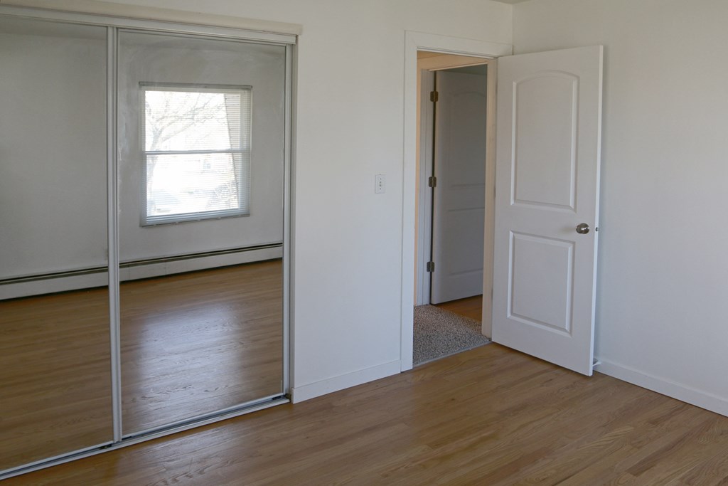 an empty room with a mirror and a door