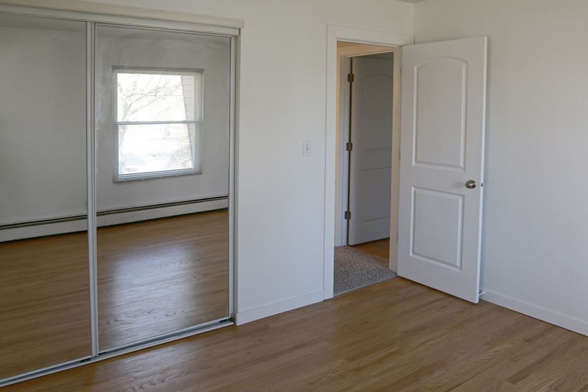 an empty room with a mirror and a door