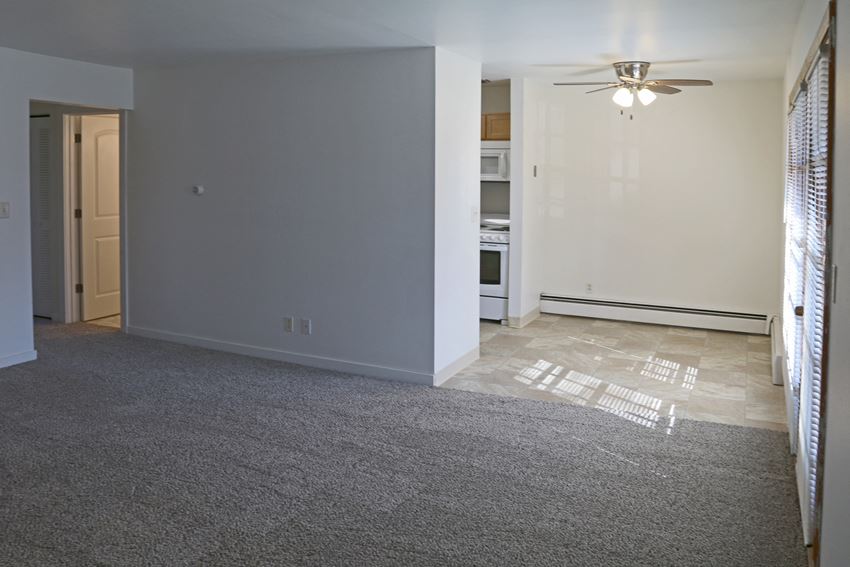 an empty living room with a ceiling fan