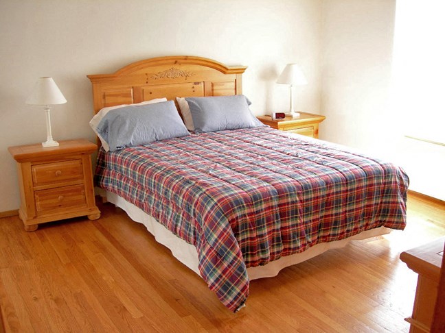 a bedroom with a bed and wooden floors
