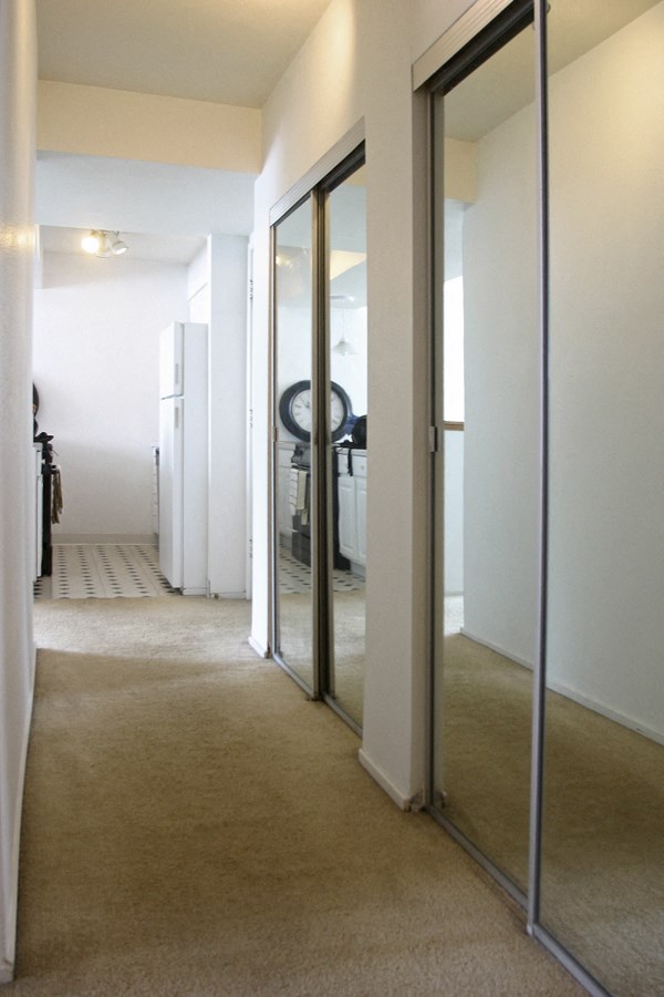 a hallway with mirrors on the wall and a carpeted floor