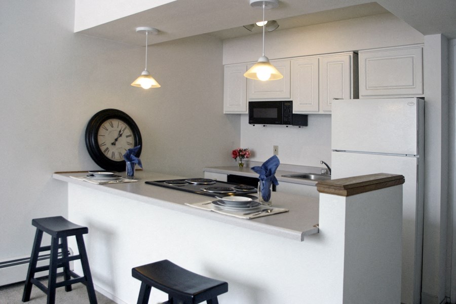 a kitchen with white cabinets and a counter top and a clock