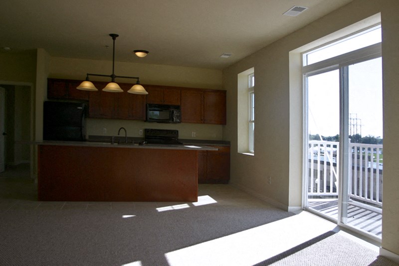 an empty kitchen with a sliding glass door to a balcony