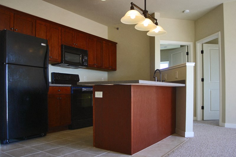 a kitchen with black appliances and wooden cabinets