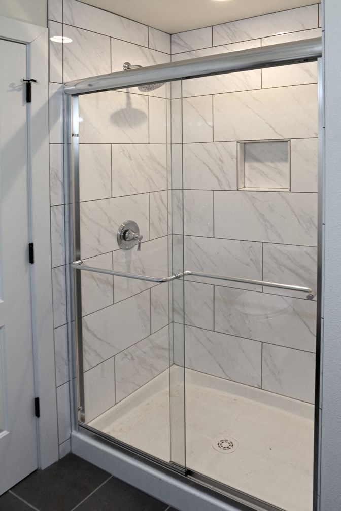 a shower with a glass door in a bathroom