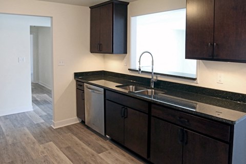 an empty kitchen with a sink and a window