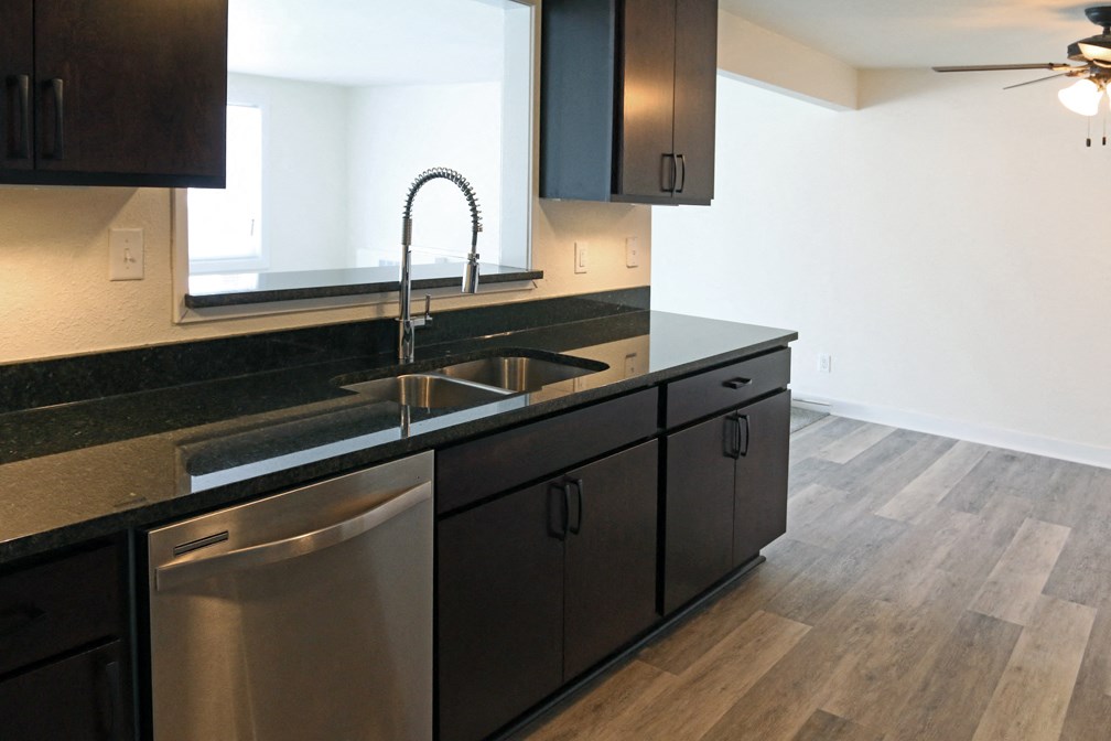 a kitchen with black counter tops and stainless steel appliances