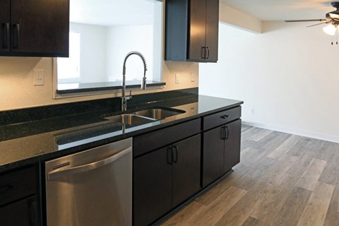 a kitchen with black counter tops and stainless steel appliances