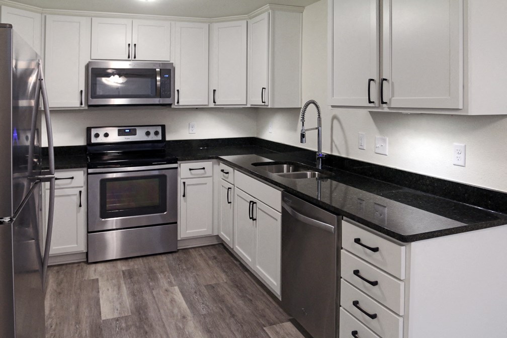 a kitchen with white cabinets and stainless steel appliances