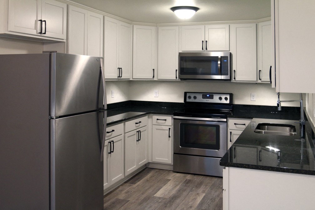 a kitchen with stainless steel appliances and white cabinets