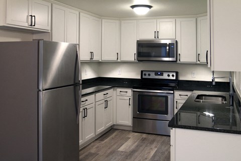 a kitchen with stainless steel appliances and white cabinets