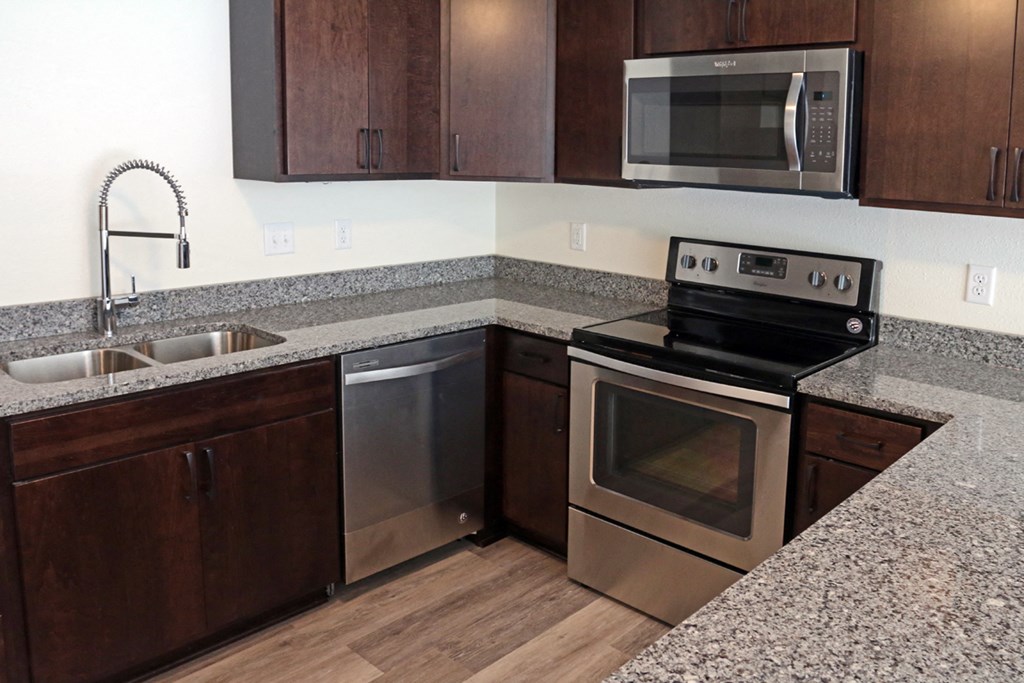 a kitchen with granite counter tops and stainless steel appliances