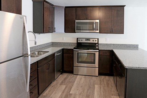 a kitchen with wooden cabinets and stainless steel appliances