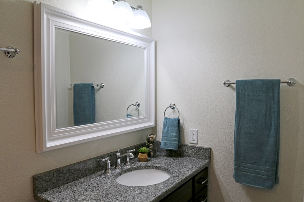 a bathroom with a sink and a mirror and a blue towel