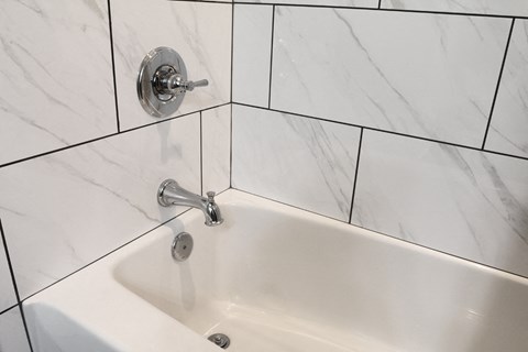 a white sink in a bathroom with white tiles