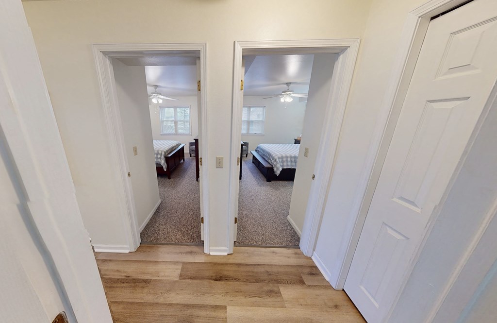 a bedroom with two closets and a door to a room with beds