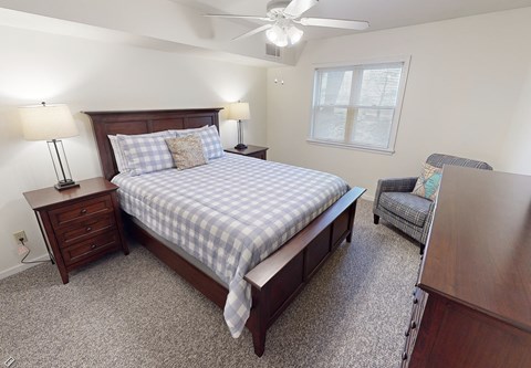 a bedroom with a bed and a desk and a chair