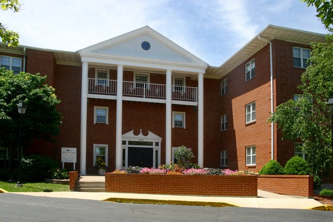 the front of a large brick building with a porch