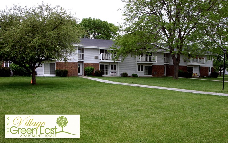 a green lawn in front of a white house