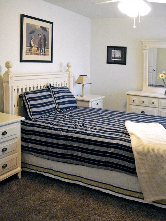 a bed with a striped comforter and two pillows on it