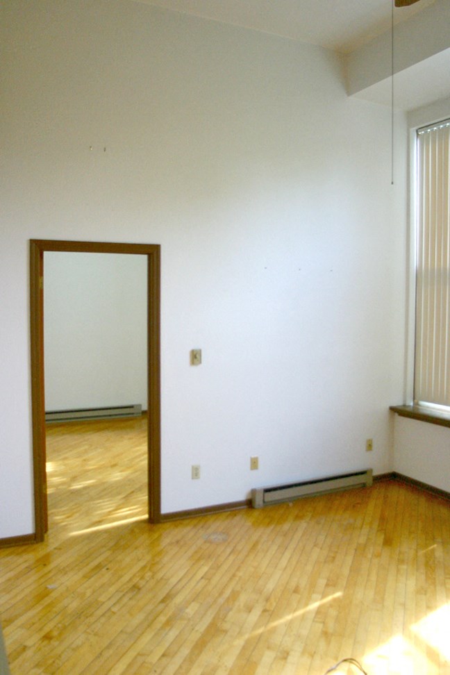 an empty room with a mirror in the middle of it