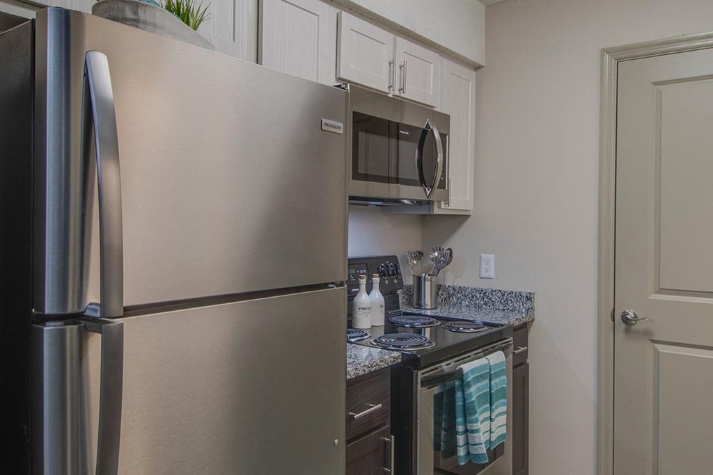 a kitchen with a stainless steel refrigerator and stove