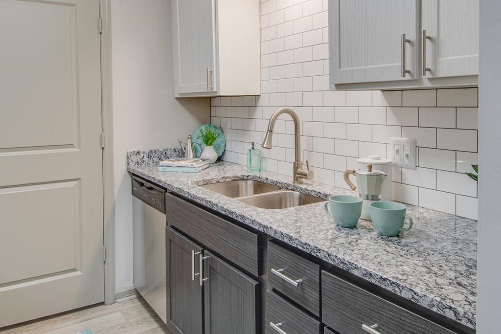 a kitchen with gray cabinets and a sink