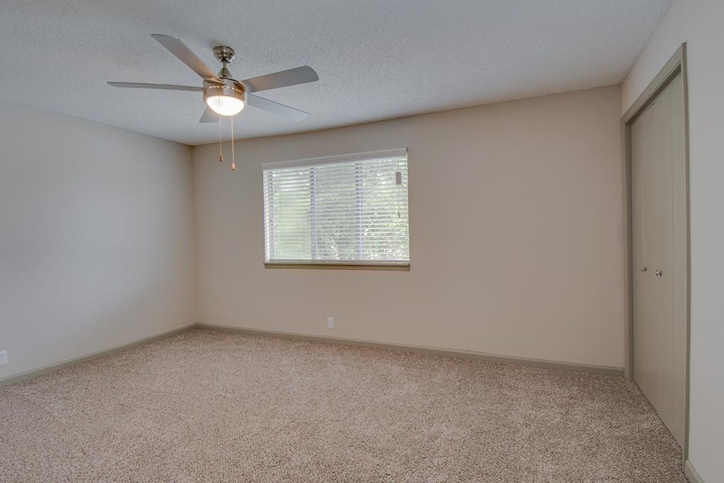 a bedroom with a ceiling fan and a window