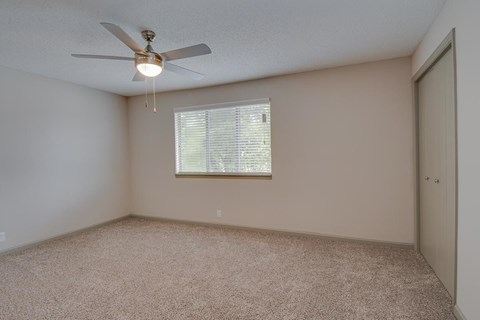 a bedroom with a ceiling fan and a window