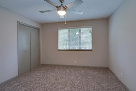 a bedroom with a ceiling fan and a window