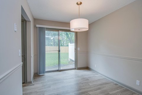 an empty living room with a sliding glass door to a yard