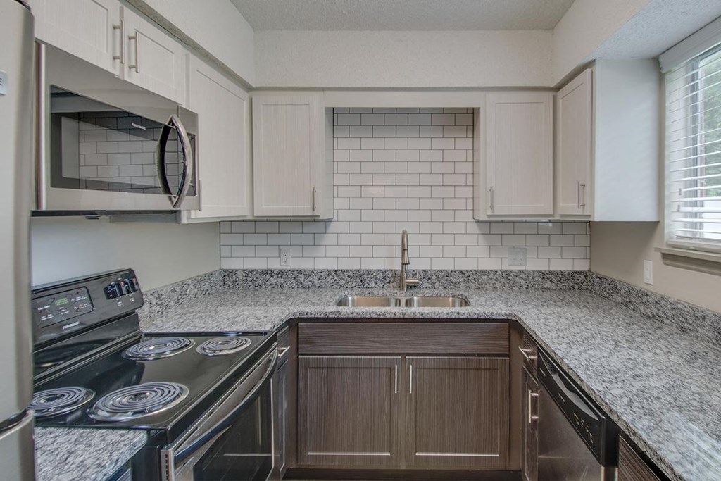 a kitchen with white cabinets and granite counter tops