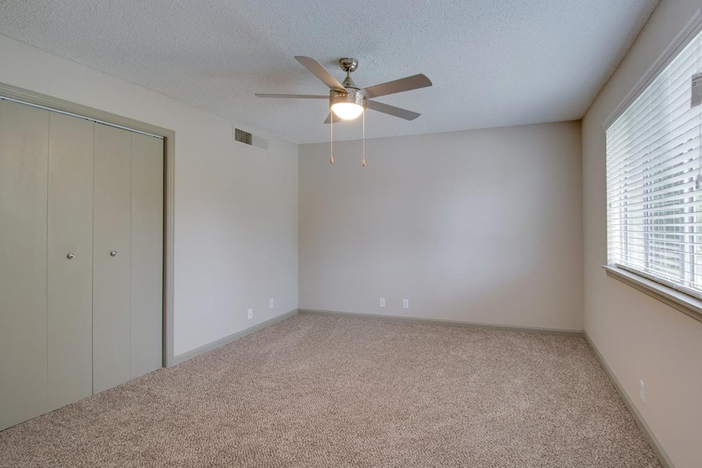 a bedroom with a ceiling fan and a closet