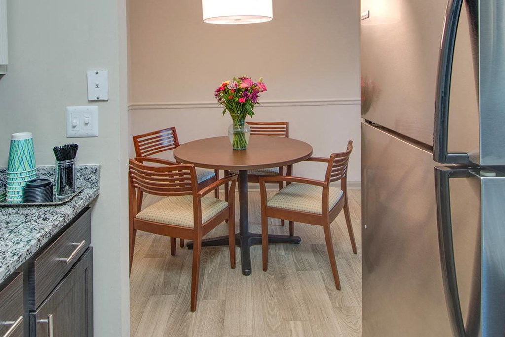 a kitchen with a table and chairs and a refrigerator