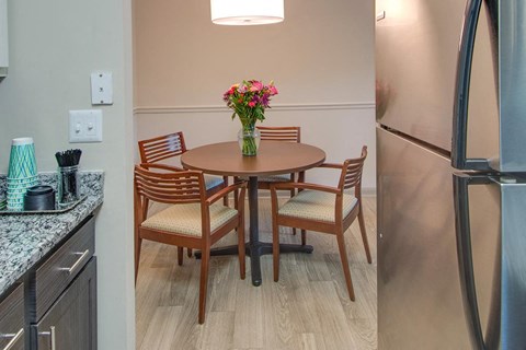 a kitchen with a table and chairs and a refrigerator