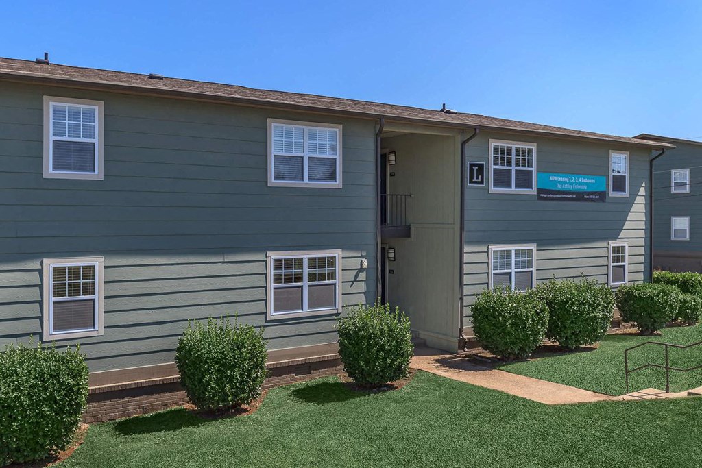 an exterior view of a home with a lawn and shrubs