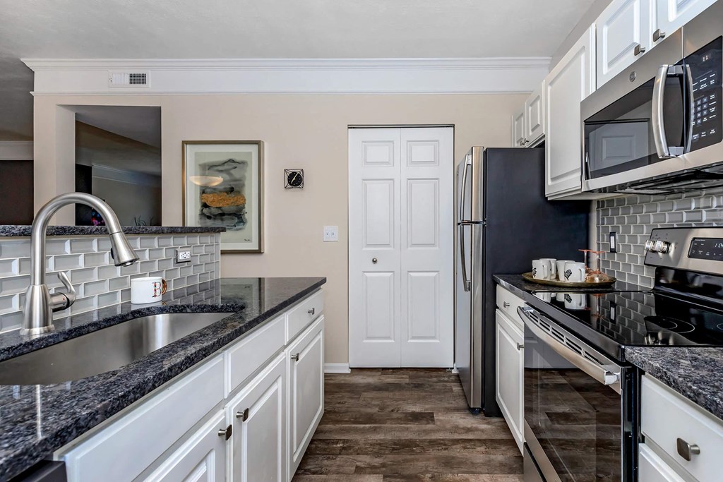 a kitchen with granite counter tops and stainless steel appliances