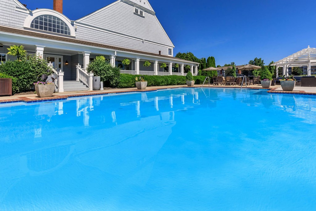 a large swimming pool with a house in the background