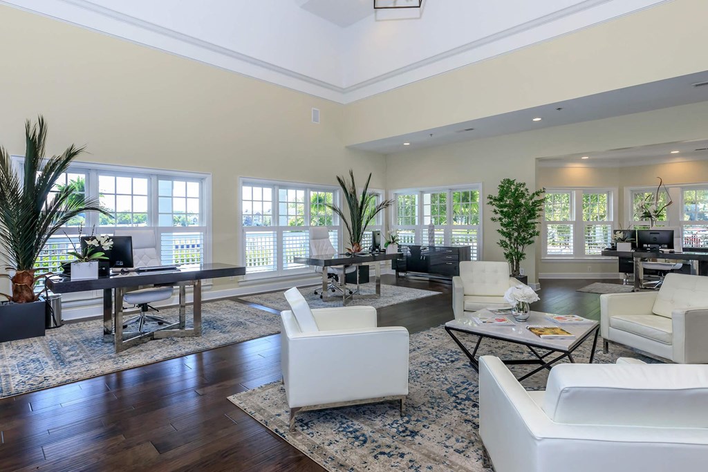 a large living room with white furniture and large windows