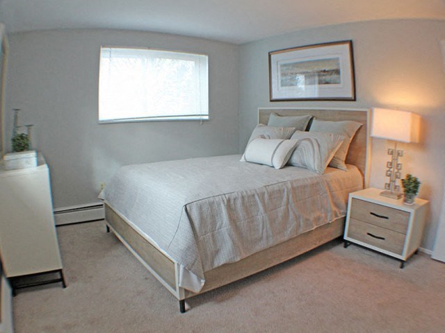 a bedroom with a bed and a window  at Valley York Apartments, Ohio