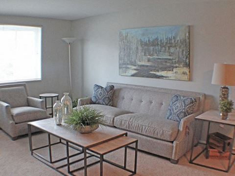 a living room filled with furniture, a large painting, and a window  at Valley York Apartments, Parma Heights, OH, 44130