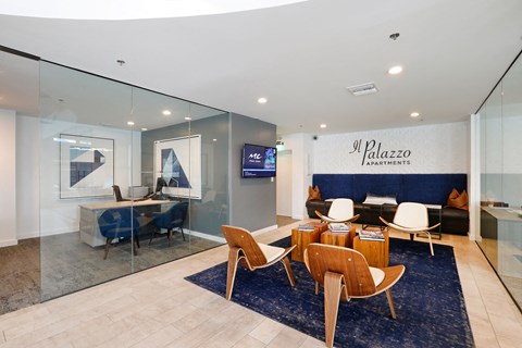 A modern living room with a glass wall and a blue rug.